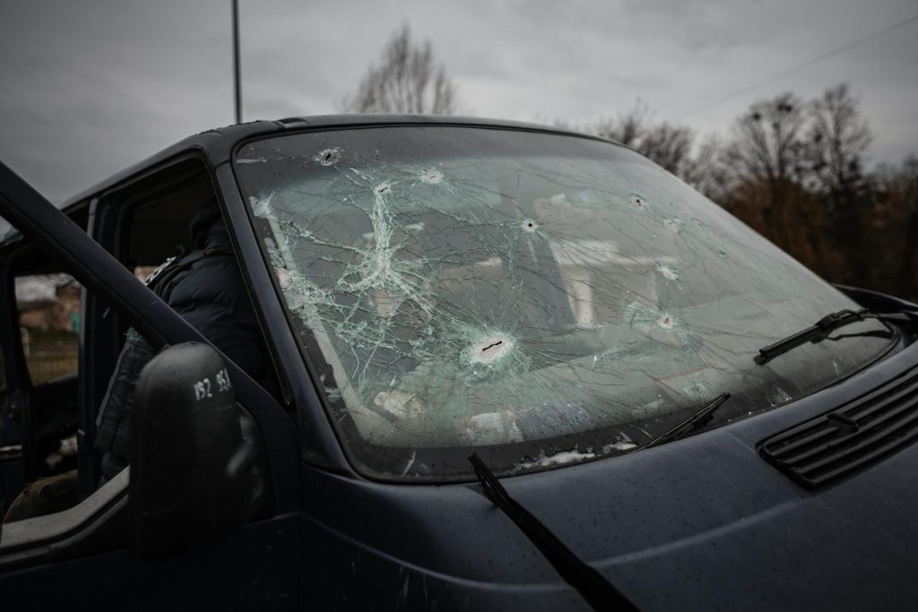 Close-up of a vehicle with a shattered windshield in Borydanka, Ukraine, reflecting turmoil.
