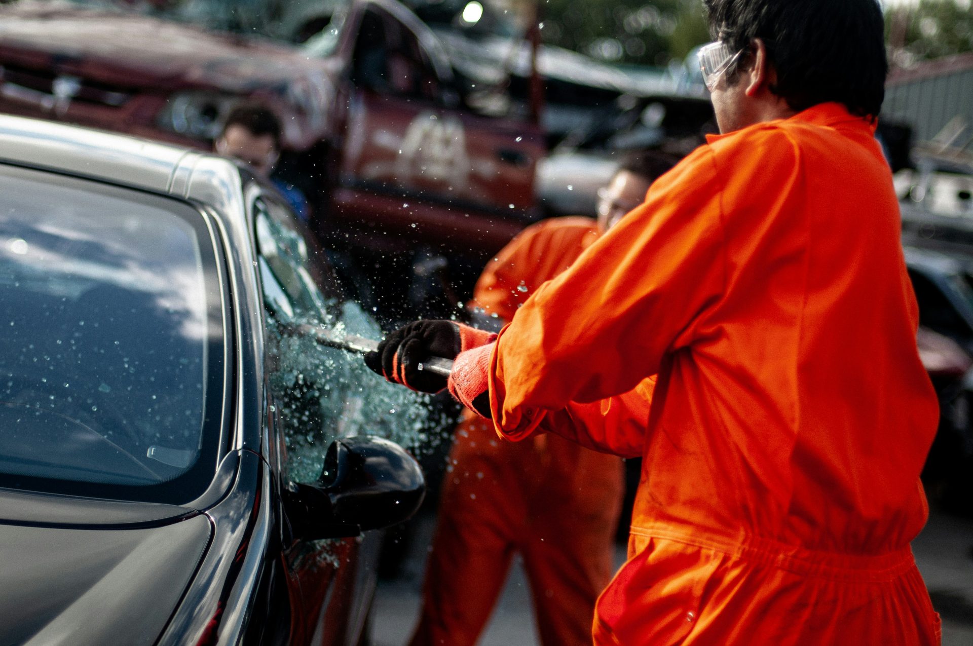 a man in an orange jumpsuit washing a car