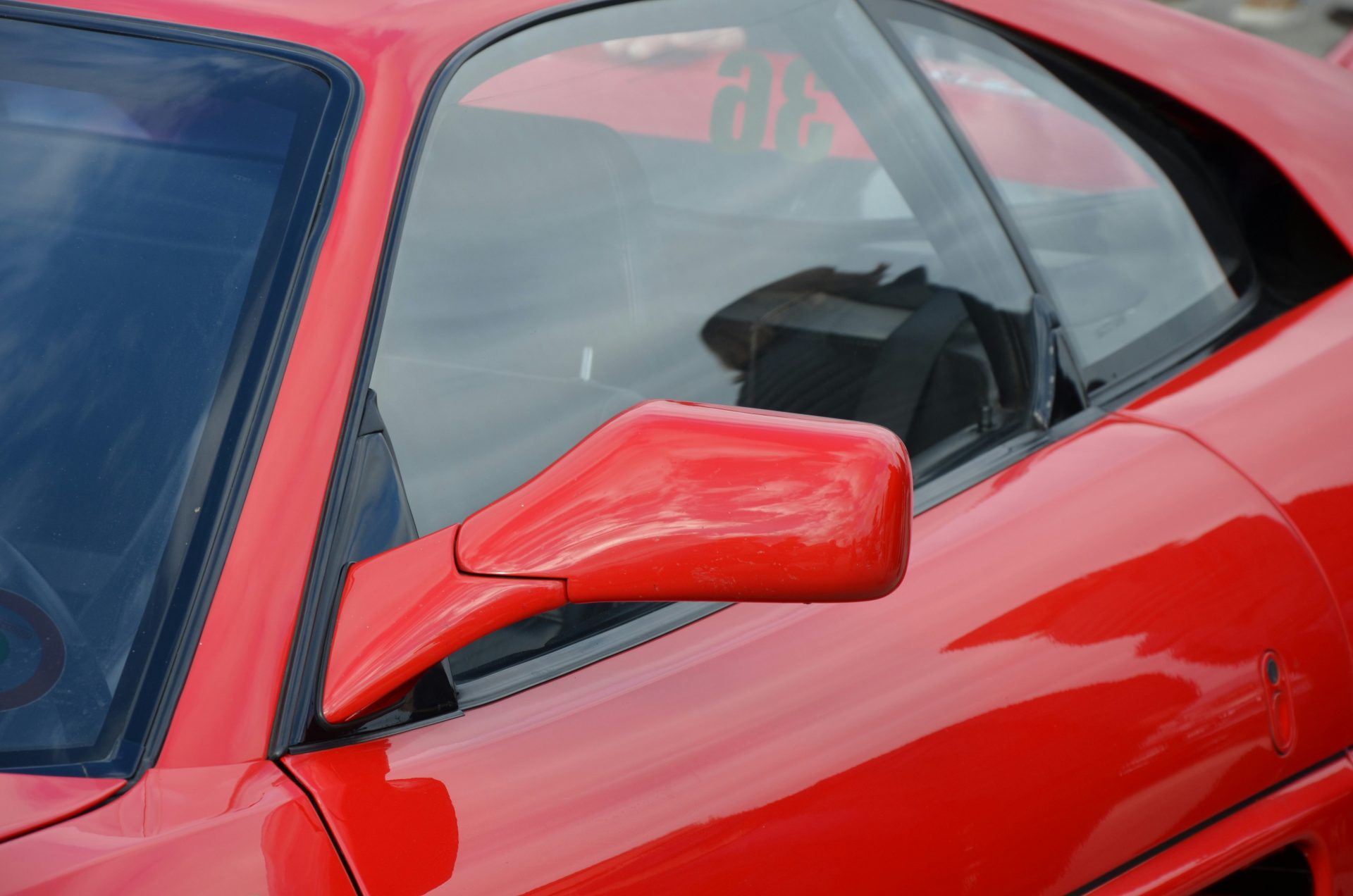 a close up of a red car's side mirror